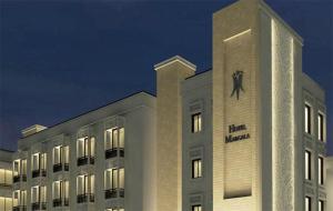 伊斯兰堡玛格拉酒店的白色的建筑,旁边有一个钟