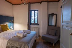 马克里尼撒Charis Guesthouse的卧室配有床、椅子和窗户。