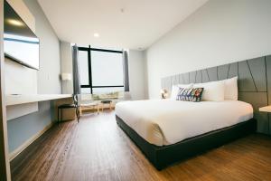 瓜埠Chill Suites Langkawi的一间卧室设有一张大床和一个大窗户