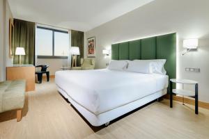 圣胡斯托德斯韦尔恩Hesperia Barcelona Sant Just的酒店客房设有一张大床和一张桌子。