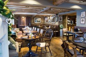 麦克尔斯菲尔德The Legh Arms Prestbury的一间带桌椅的餐厅和一间酒吧