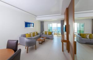 阿吉曼Ramada by Wyndham Beach Hotel Ajman的带沙发、椅子和桌子的客厅