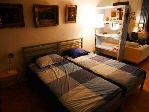 多德雷赫特StudioPlus的卧室内的两张床,配有灯和沙发