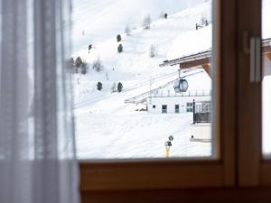索尔登Glanzer Homes Hochsölden的从窗户可欣赏到雪覆盖的斜坡的景色