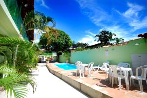 塞古罗港Pousada Tapuia的一个带白色椅子的庭院和一个游泳池