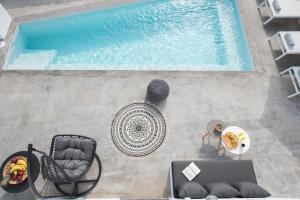 弗通White Orchid Suites的享有带椅子和桌子的游泳池的上方景色
