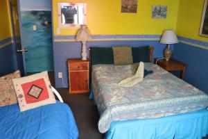 皮克顿亚特兰蒂斯背包旅馆的一间卧室配有一张床、一盏灯和一张四柱床