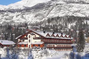 海姆瑟达尔法妮土伦酒店的山前大雪覆盖的建筑