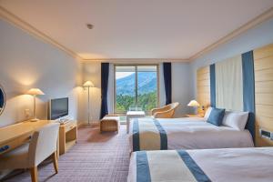 京都L'Hotel de Hiei的酒店客房配有两张床和一张书桌