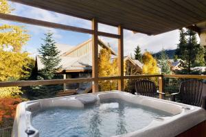 惠斯勒冰川里奇全季出租度假屋的庭院内的按摩浴缸,享有房子的景色