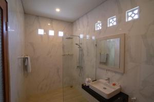 塞米亚克居安达别墅酒店的带淋浴、盥洗盆和镜子的浴室