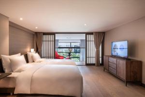 上海上海虹桥诺富特全套房酒店的酒店客房设有两张床和一台平面电视。