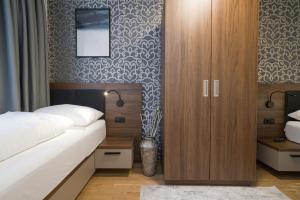 维也纳MyApartments Vienna的一间卧室配有一张床和一个木制橱柜