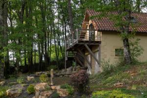 CastelsStudio cosy perché dans les arbres au coeur du Périgord proche Sarlat的房屋的一侧设有木甲板