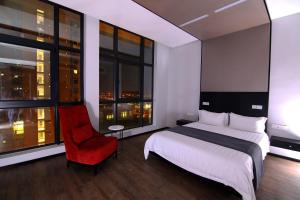 哈博罗内Room50Two的酒店客房,配有一张床和一张红色椅子