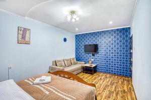阿拉木图Апартаменты Орбита-2, 11的客房设有床、沙发和电视。