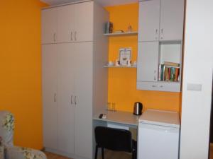 大特尔诺沃Apartment Moni的厨房配有白色橱柜和书桌。