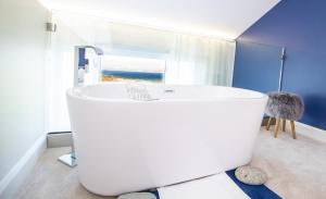 克利夫登Connemara Sands Hotel & Spa的带窗户的浴室内的白色浴缸
