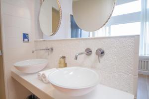 克利夫登Connemara Sands Hotel & Spa的浴室设有2个水槽和2面镜子