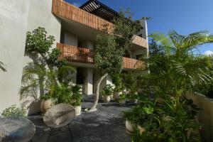 图卢姆Casa Agape Hotel Tulum with Beach Club Access的前面有一堆植物的建筑