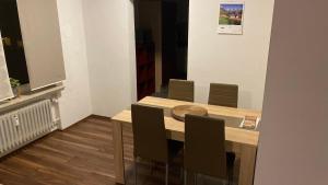 LandwehrhagenFerienwohnung Schäfer的一间带木桌和椅子的用餐室