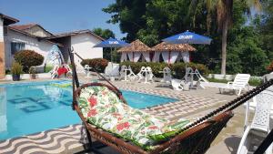 索雷Hotel Marajó - Turismo de Experiência的度假村旁的游泳池设有椅子和吊床