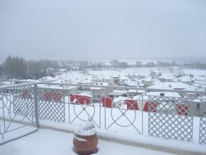 卡斯托里亚迪米特拉旅馆 的停车场的雪景,有雪盖屋顶