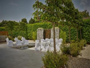 切尔滕纳姆Cotswold Grange的花园里的一排白色椅子