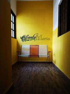 HomúnHotel Santa María Homun的客房内的黄色墙和长凳
