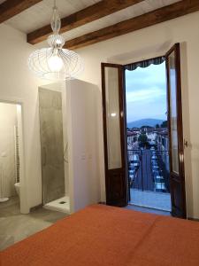 佛罗伦萨Affittacamere Ramazzini的一间卧室设有大窗户和吊灯