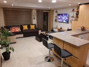 昆卡Condominio La Victoria, Departamento en Cuenca 1的厨房以及带沙发和桌子的客厅。