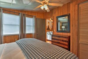 FriscoOuter Banks Island Cottage - 1 Mi to Frisco Beach!的一间卧室配有一张床、镜子和吊扇