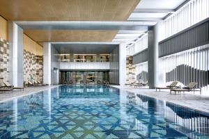 顺义北京首都机场东海康得思酒店 - 朗廷酒店集团全新品牌的一座带椅子的大型游泳池