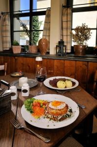 普劳恩阿尔特斯特·伽斯特温特斯查弗马斯彻-普伦斯酒店的一张桌子,上面放着两盘食物和一杯葡萄酒