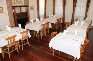KandosRailway Bistro - Kandos的用餐室配有白色的桌子和木椅