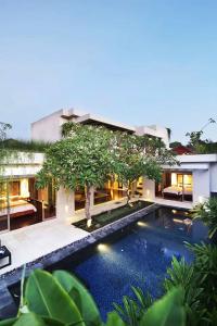 金巴兰Kedonganan Beach Villas的一座别墅,在一座建筑前设有一个游泳池