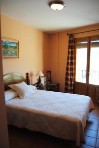 里奥帕尔埃尔阿拉卡乡村旅馆的一间卧室配有一张床、一张书桌和一个窗户。