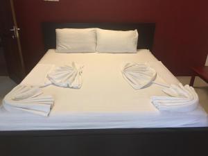 贾夫纳Nallur Residence的一张床上铺有白色床单和遮阳伞