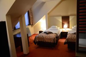 罗兹Agat Hotel的酒店客房设有两张床和窗户。