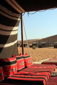 Al WāşilNomadic Desert Camp的一群红色和白色的袋子坐在海滩上