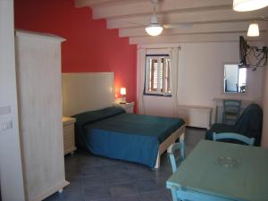 乌斯蒂卡Residence Timeo的卧室配有一张床和一张桌子及椅子