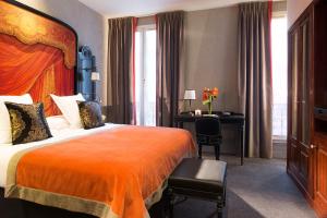 巴黎Le Belmont Paris的配有一张床和一张书桌的酒店客房