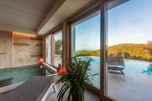 蓬塔阿拉Villa Margherita Wellness & Golf - "Your Private Punta Ala"的一座带游泳池和大窗户的房子