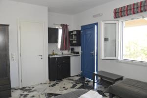 伊拉克利亚岛Anna's Place Rooms的一间设有蓝色门和水槽的小厨房