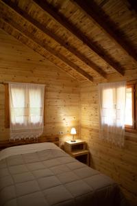 Leskovik法尔马索提拉农家乐的一间卧室设有一张床和两个窗户。
