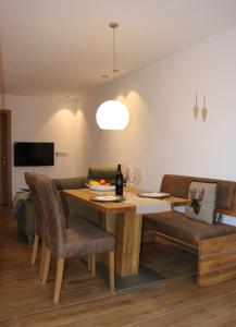 万丹斯Ferienhaus Raich的一间带木桌和椅子的用餐室