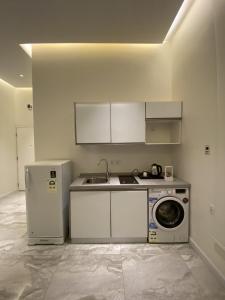 利雅德Sadan Furnished Apartments的厨房配有水槽和洗衣机