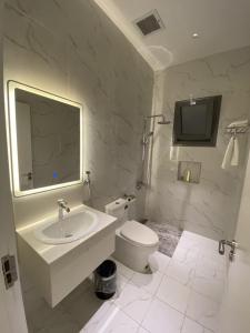 利雅德Sadan Furnished Apartments的白色的浴室设有水槽和卫生间。
