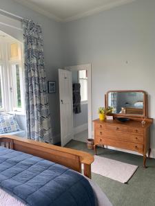 哈士汀Hawkes Bay Villa-Beechwood的一间卧室配有床、镜子和梳妆台