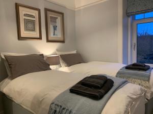 洛西茅斯Cliffside的卧室内的两张床,配有两条毛巾
